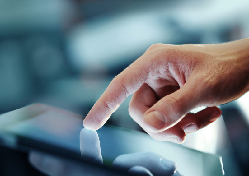 Hand interacting with tablet touchscreen